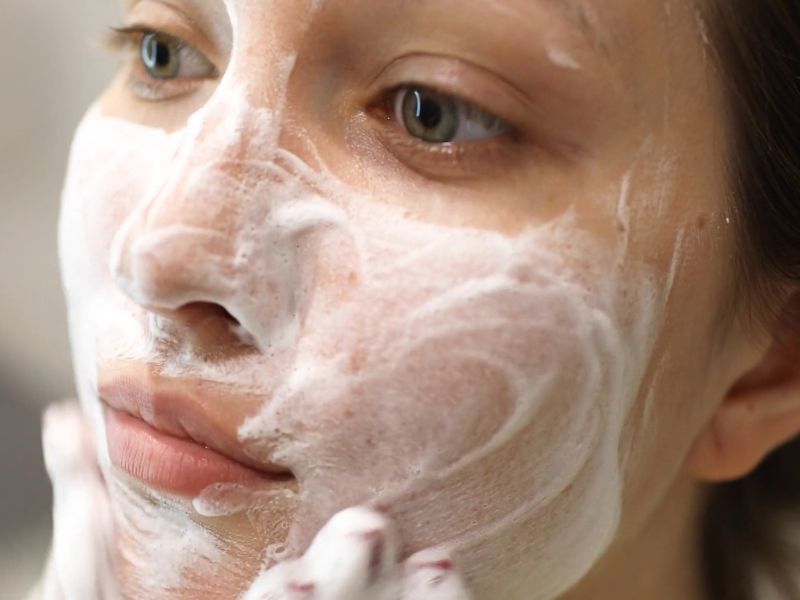 devojka pere svoje lice sa blagim klenzerom